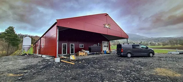 Rødt fjøs i regnfylt landskap