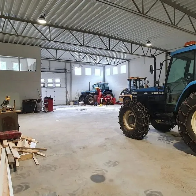 Blå traktor inne i lagerbygg